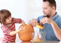 Man and a child carving a pumpkin