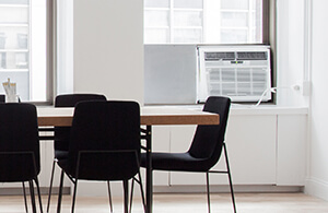 Table in an office with a window AC unit