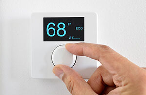 Hand adjusting a thermostat