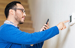 Man adjusting thermostat