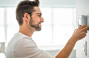 Man looking at his thermostat