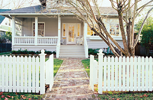 front of a home with white picket fence