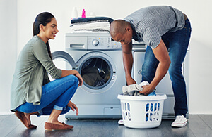 Washing machine using hot water from a tankless water heater