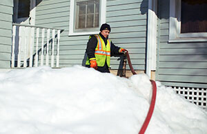 Oil delivery tech trying to get through the snow to a fill pipe