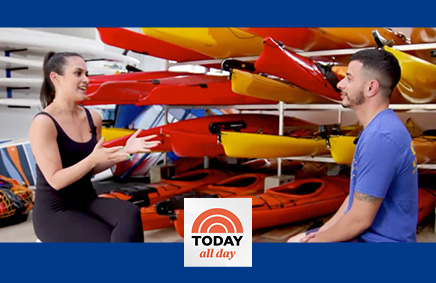 Woman and man talking in front of canoes