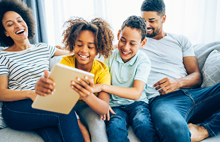 Family on soft looking at iPad